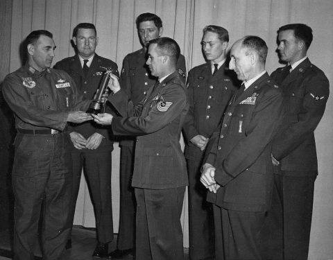 MSgt. James E. Cazel and Sembach Rifle team present recent trophy to Base Commander Col. Frontczak. Circa 1962